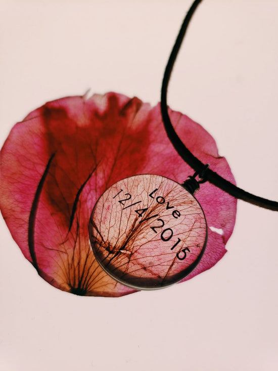 Custom glass pendant etched with Love 12/4/2015 on a pink petal 