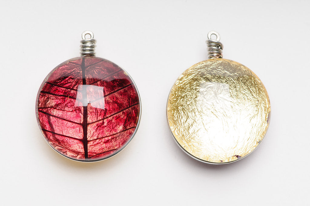 Front and back of the Gilded Poinsettia Pendant with the front showing the petal and the back showing the gold
