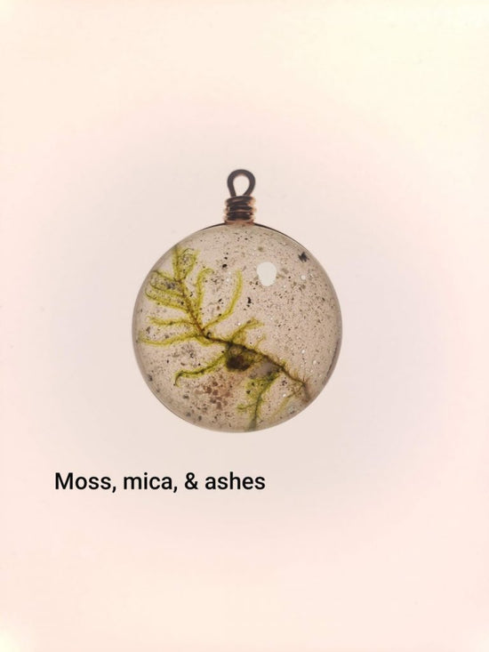 Glass pendant filled with moss, mica, and ashes