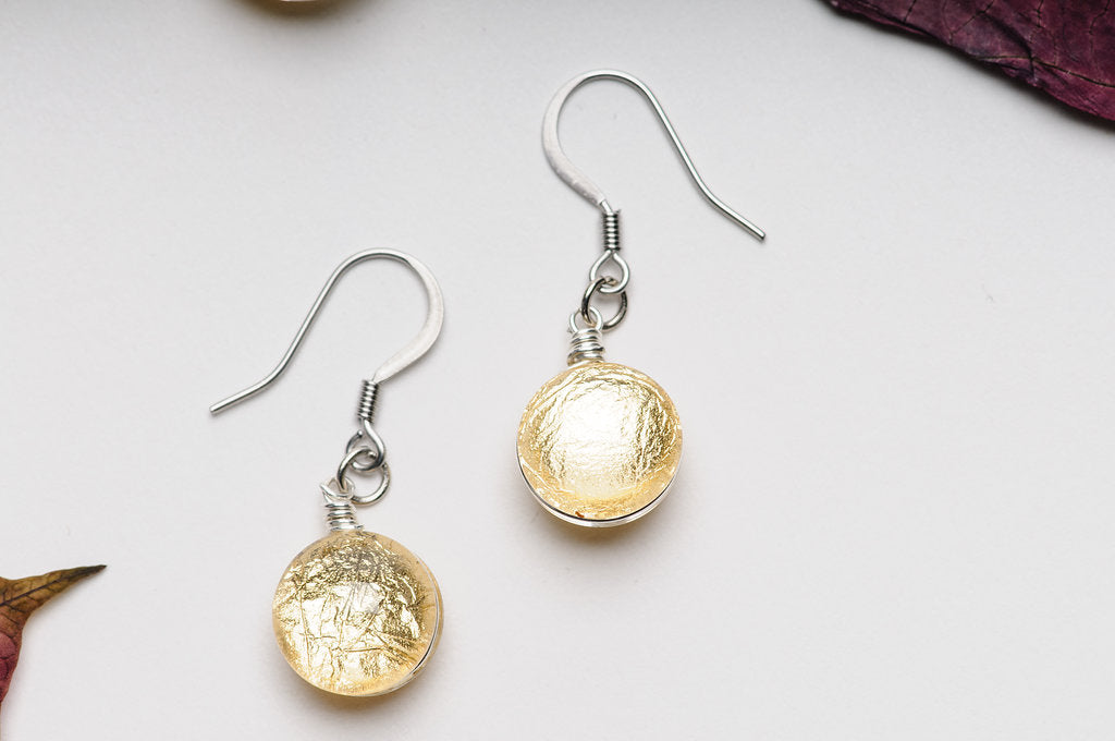 Gold/Silver Moons Dangle Earrings laying on a white background 